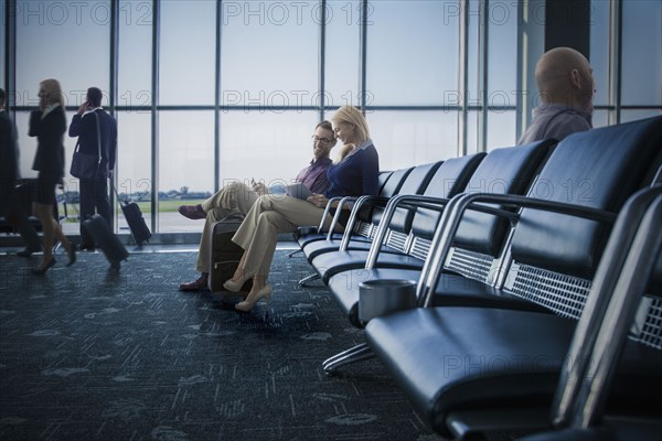 Caucasian couple using digital tablet in airport