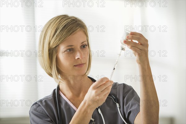 Caucasian nurse filling syringe