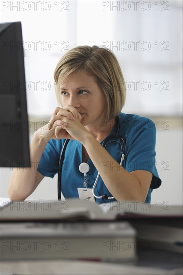 Caucasian surgeon reading books and using computer