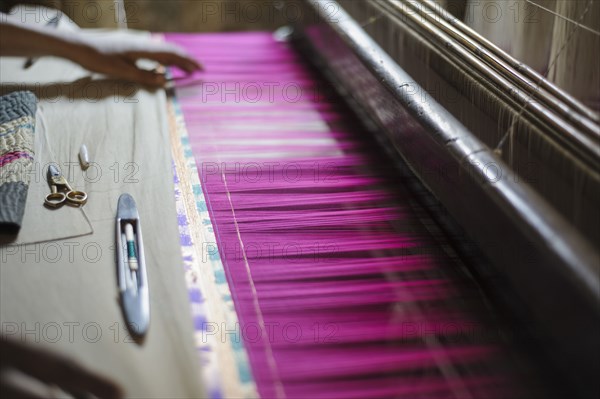 Hand feeling threads in loom