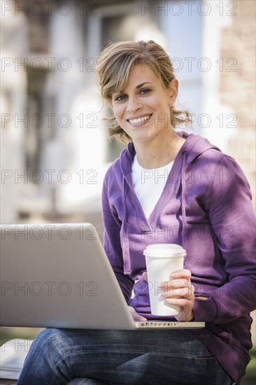 Caucasian student using laptop on campus