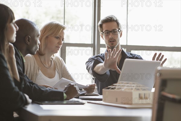 Business people using laptop in meeting