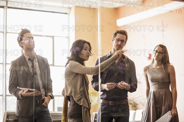 Business people writing on glass wall