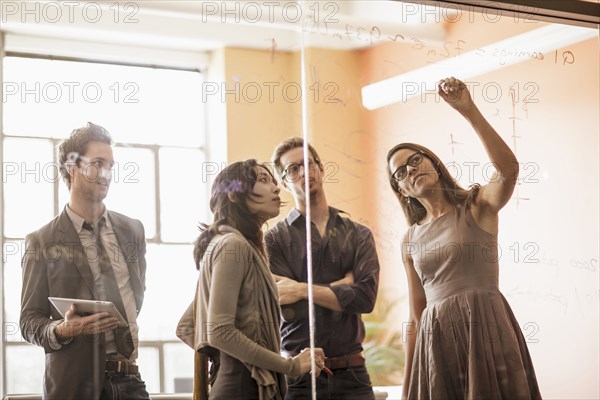 Business people writing on glass wall