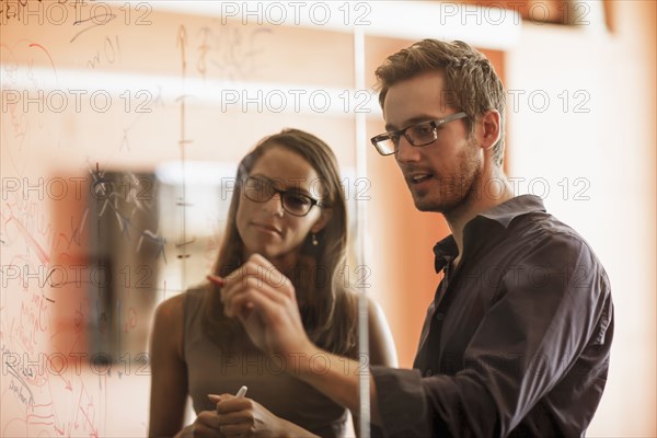 Businessman writing on glass wall