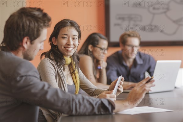 Mixed race businesswoman smiling in meeting