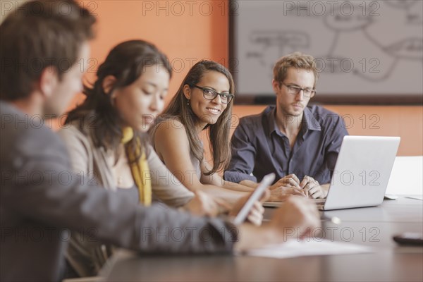 Mixed race businesswoman smiling in meeting