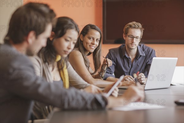 Mixed race businesswoman smiling in meeting