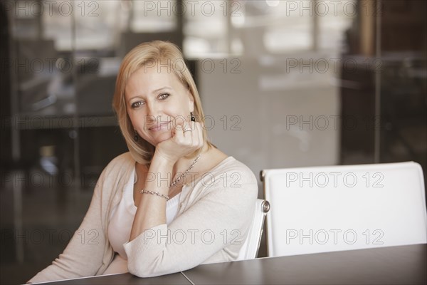 Caucasian businesswoman smiling at desk