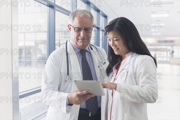Doctors using tablet computer in hospital
