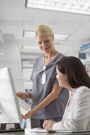 Doctor and nurse working at computer in hospital