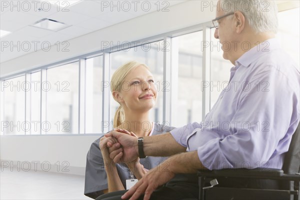 Caucasian nurse talking to patient in hospital