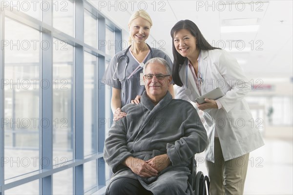 Doctor and nurse smiling with patient in hospital