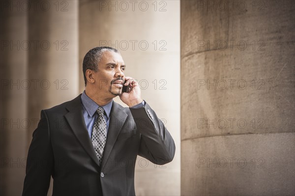 Mixed race businessman talking on cell phone