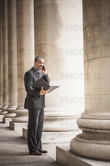 Mixed race businessman talking on cell phone