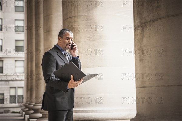 Mixed race businessman talking on cell phone