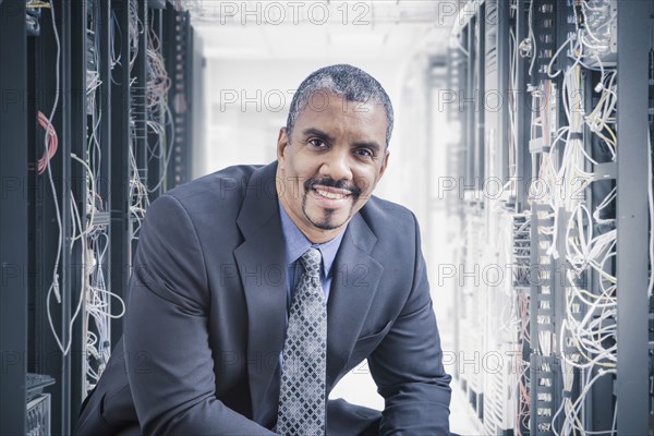 Mixed race businessman sitting in server room