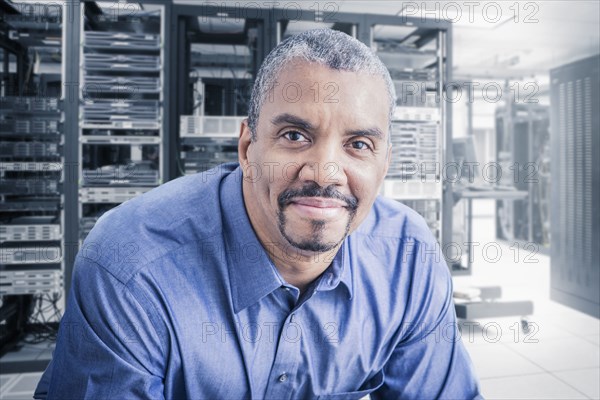 Mixed race businessman sitting in server room