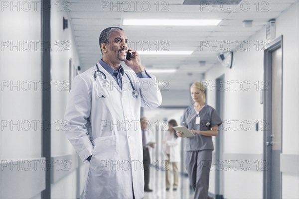 Mixed race doctor talking on cell phone in hospital