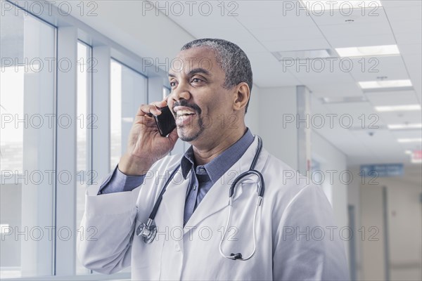 Mixed race doctor talking on cell phone in hospital