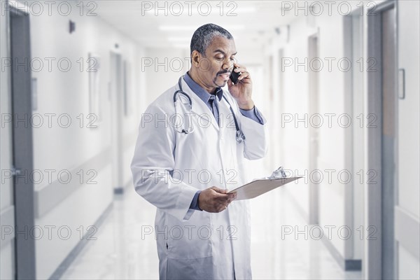 Mixed race doctor talking on cell phone in hospital