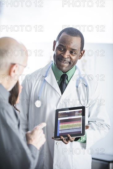 Doctor showing tablet computer to patients