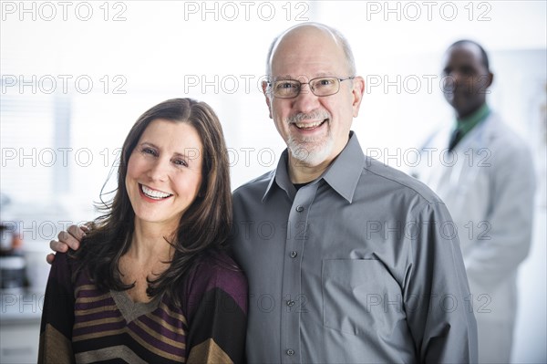 Smiling couple standing in doctor's office