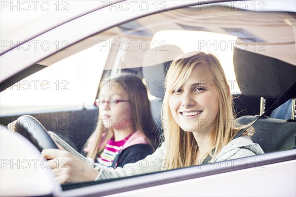 Woman driving with little sister
