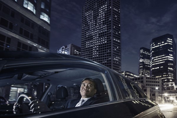 Pacific Islander businessman driving on city street