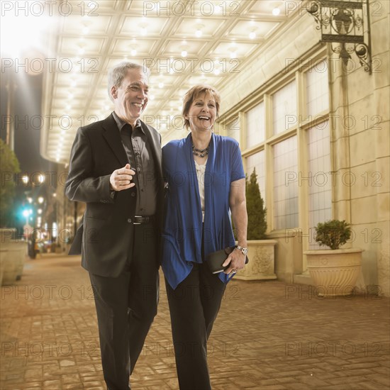 Caucasian couple walking on city street