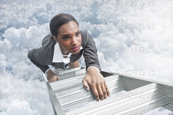 African American businesswoman climbing ladder