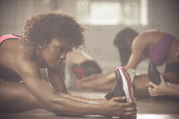 Black women stretching in gym