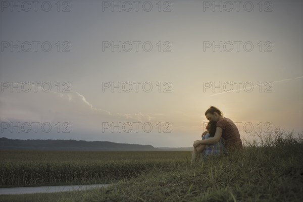 Caucasian mother and daughter hugging in field