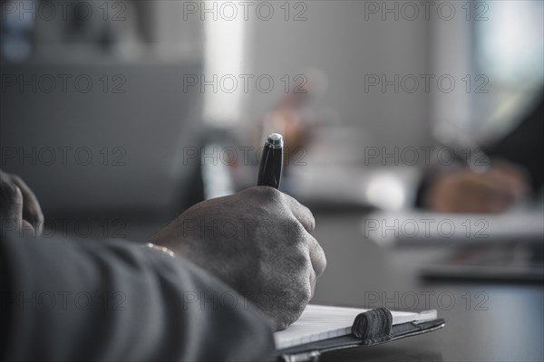 Businessman taking notes in meeting