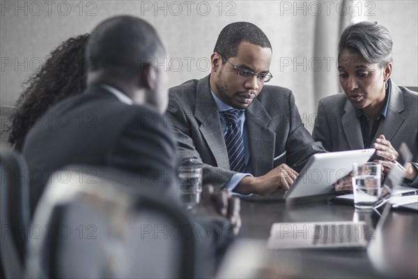 Business people using digital tablet in meeting