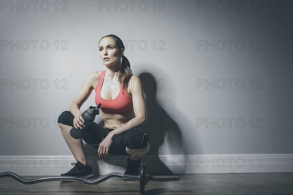 Caucasian woman in sportswear resting with water bottle