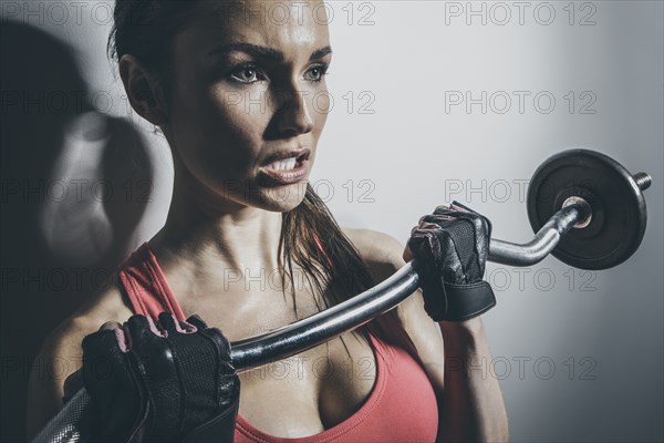 Close up of Caucasian woman lifting barbell