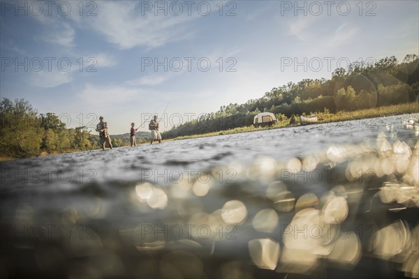 Three generations of Caucasian men fishing in river