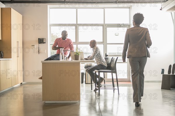 Business people relaxing in office kitchen