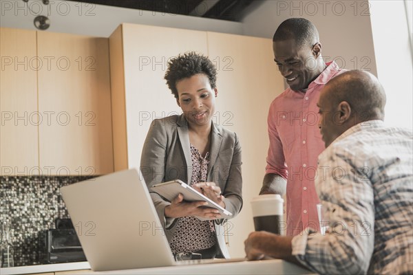 Business people using digital tablet in office kitchen