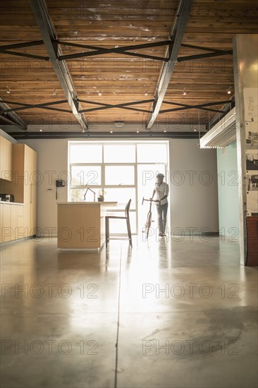 Black businessman with bicycle in office kitchen