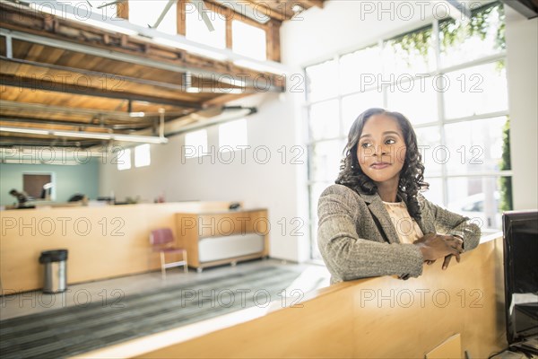 African American businesswoman standing over cubicle in office