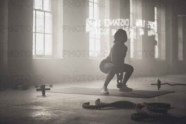 Virtual words circling Black athlete lifting kettlebell