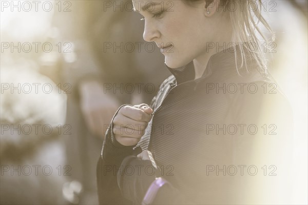 Close up of Caucasian woman zipping jacket