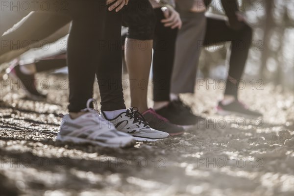 Close up of runners stretching in a row