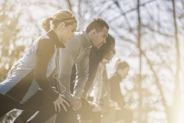 Close up of runners stretching in a row