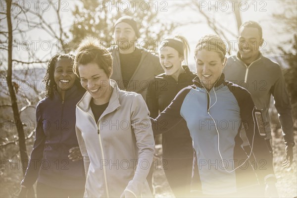 Laughing friends walking on forest path