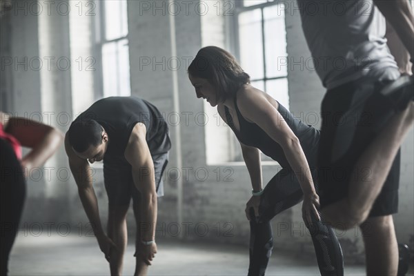 Athletes stretching legs in gym