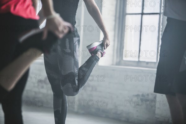 Athletes stretching legs in gym