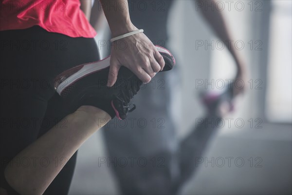 Athletes stretching legs in gym